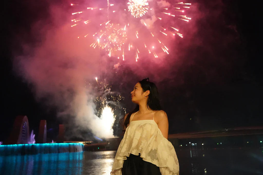 遊客於富國島煙火秀與綻放的煙火合影