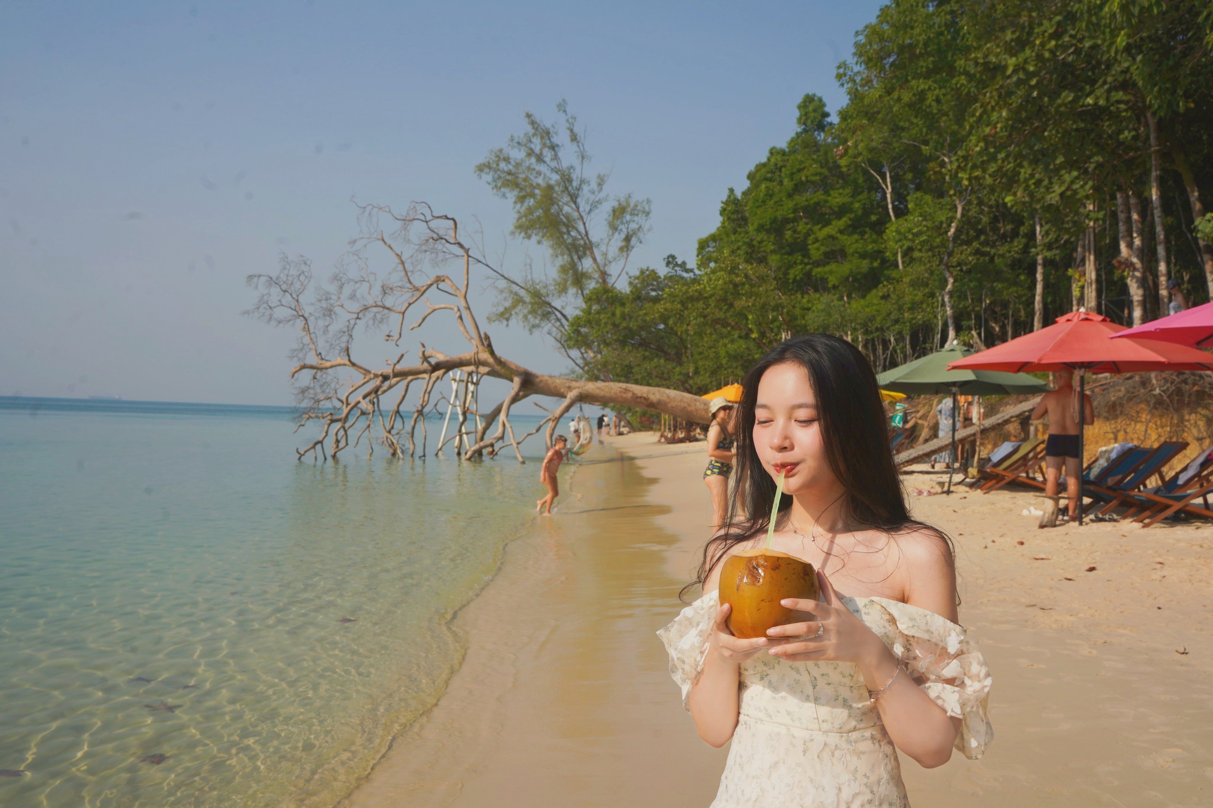 富國島沙灘上正在喝椰子汁的遊客