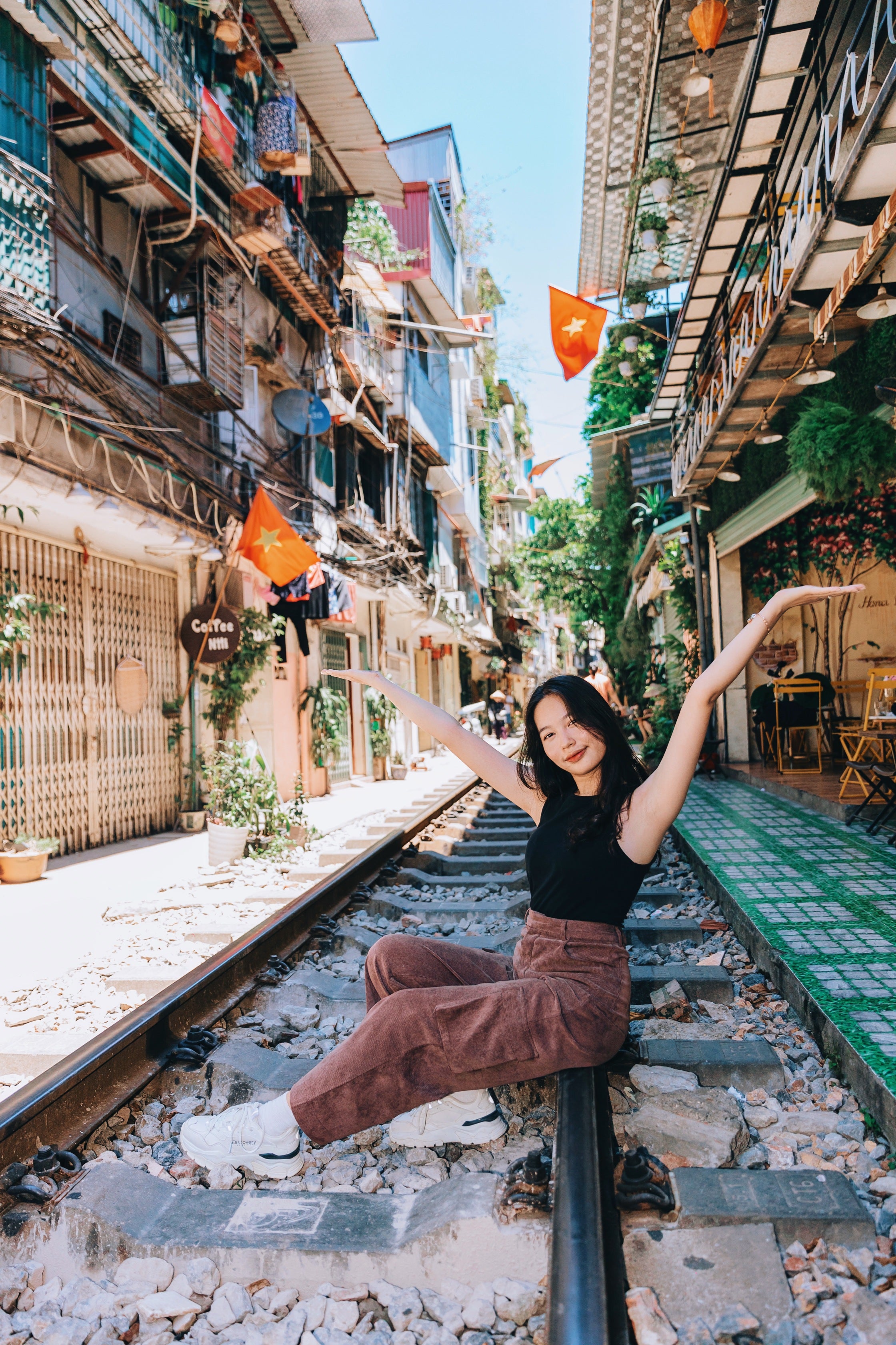 North_Vietnam_Hanoi_Train_Street_Thao_Sitting_on_Train_Track.jpg